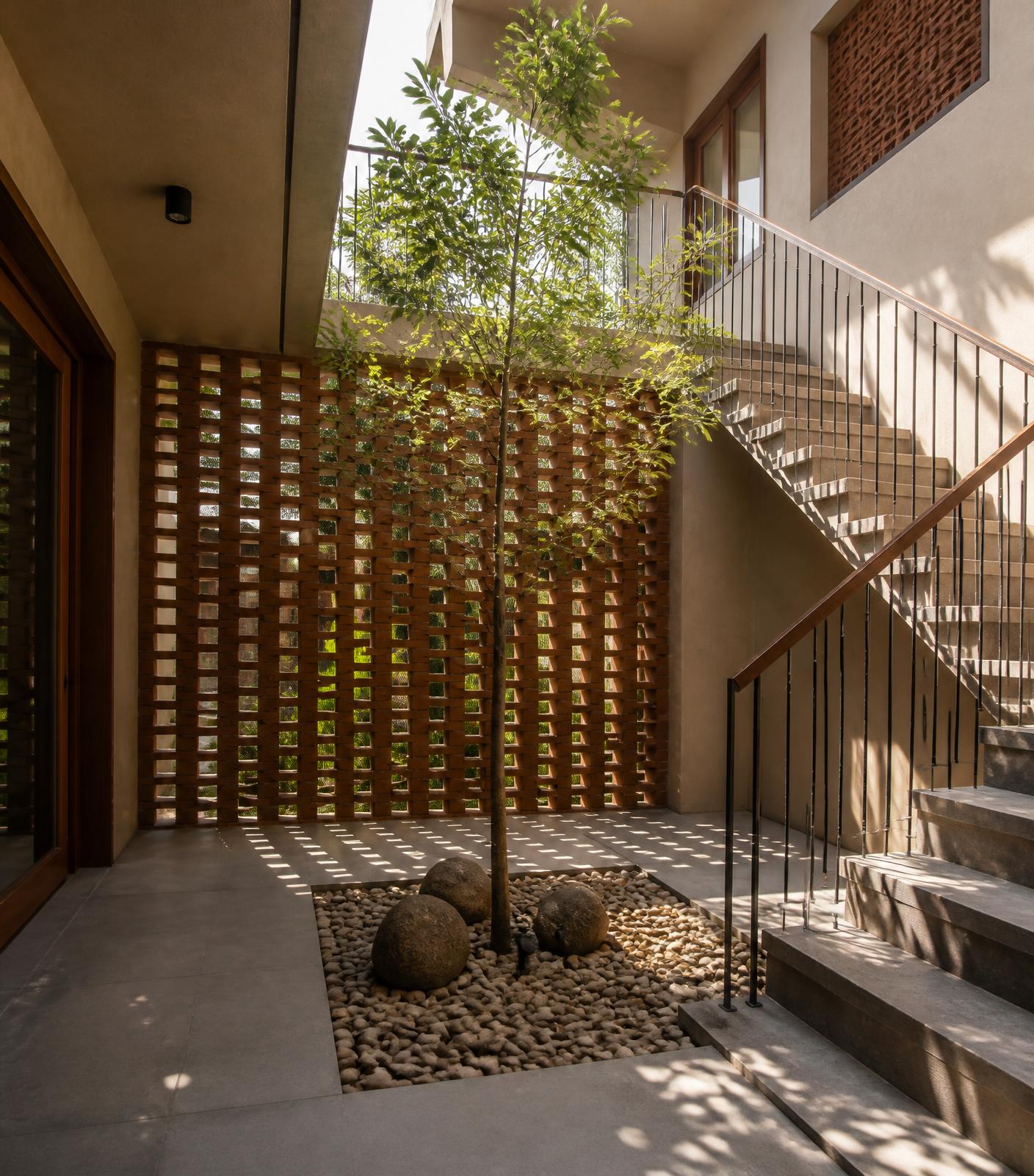 Internal courtyard of a Chennai home with brick jaali wall and natural light